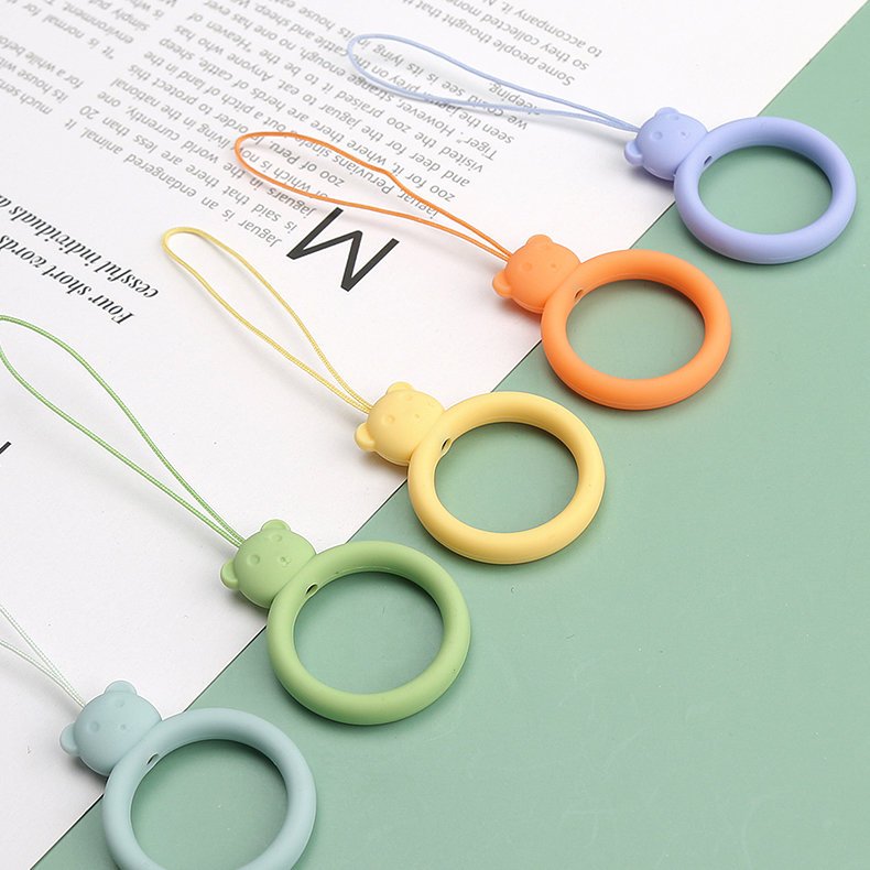 Um cordão de silicone para um anel de urso de telefone em um dedo preto
